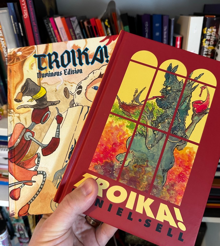 The covers of the two different versions of Troika! that I own.