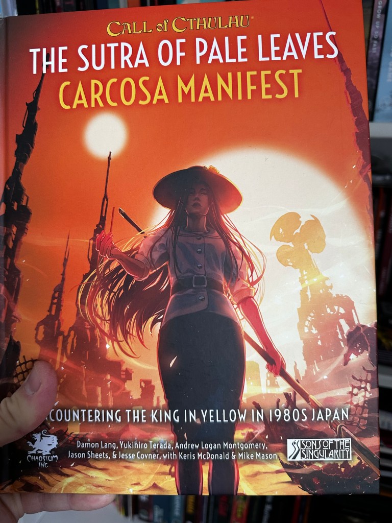 The cover of the Sutra of Pale Leaves, Carcosa Manifest. a woman in a pointed straw hat walks towards us with the two suns of Carcosa behnd her