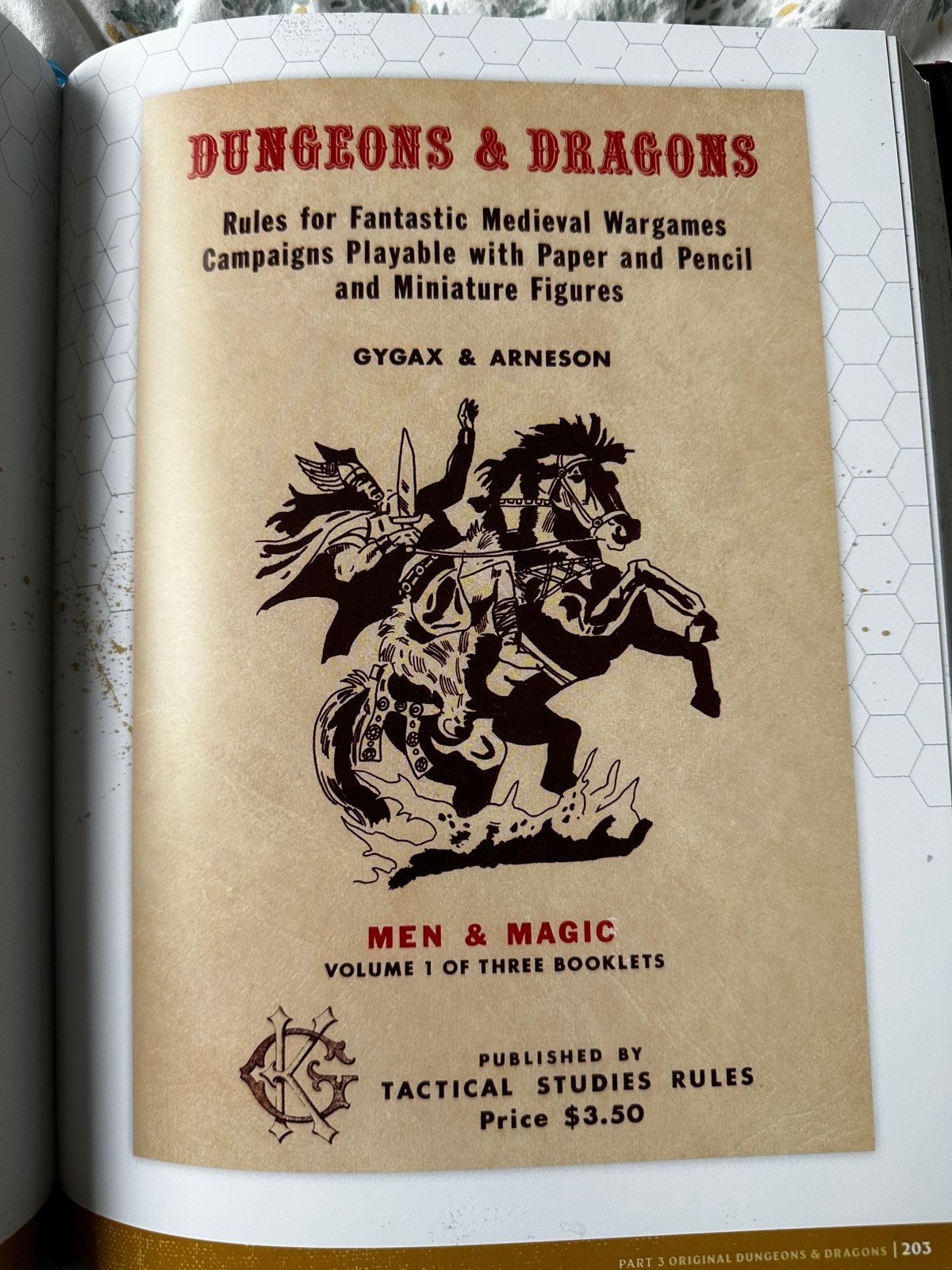 The cover of the original D&D book, Men & Magic. It is an off-white/brown colour. It has an illustration in black and white of a warrior on a rampant horse. Its from the Making of the Original Dungeons & Dragons book.