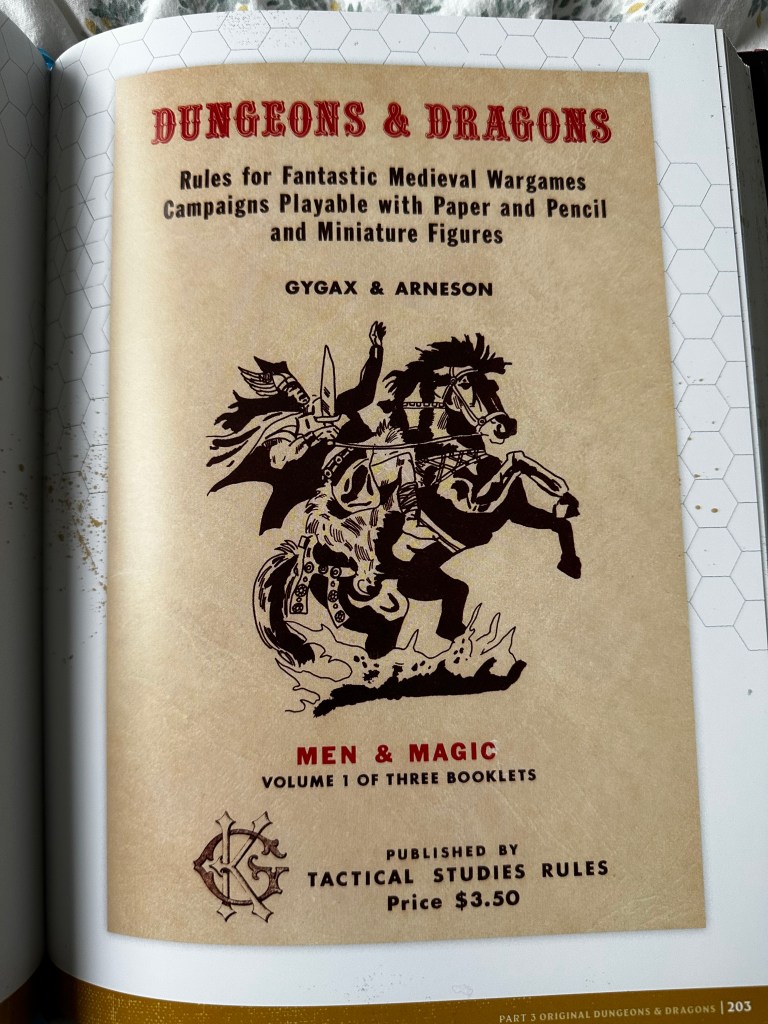 The cover of the original D&D book, Men & Magic. It is an off-white/brown colour. It has an illustration in black and white of a warrior on a rampant horse. Its from the Making of the Original Dungeons & Dragons book.