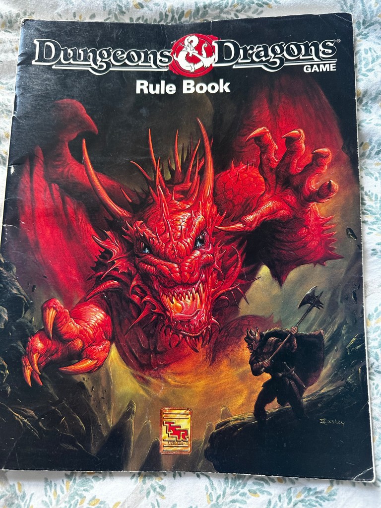 Dungeons and Dragons Game Rule Book cover. A red dragon menaces a warrior wielding an axe.