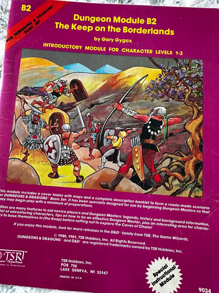 The cover of B2, The Keep on the Borderlands. A purple cover with the name of the module and a colour illustraiton in the middle: a piched battle on the road between adventurers and monsters.