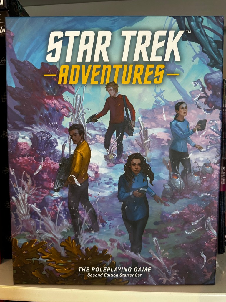 Cover of the Star Trek Adventures 2E Starter Set featuring a group of Star Fleet officers ont he surface of a planet.